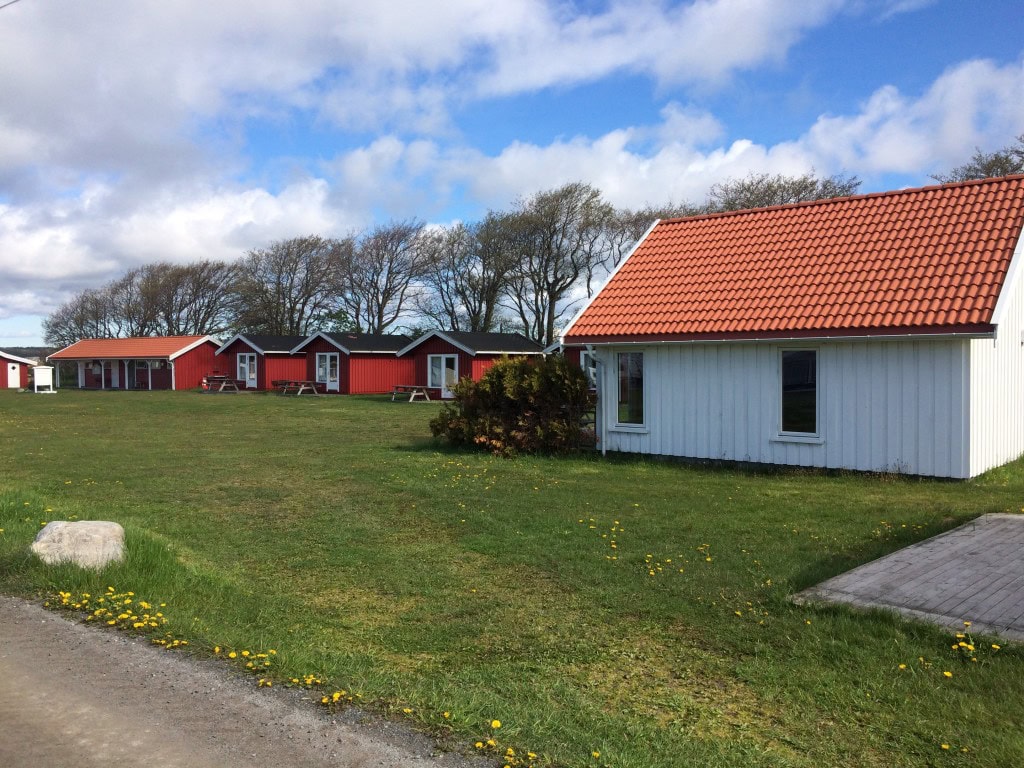 Ferie- og campinghytter på Jomfruland, idyllisk campingplass med moderne fasiliteter, utsikt over havet, og naturskjønne omgivelser, perfekt for familier og eventyrlystne.